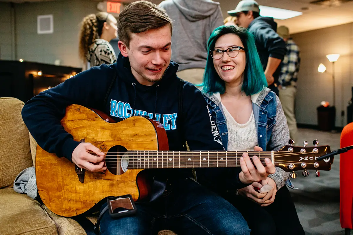 Young Adults hanging out playing guitar